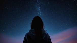 満天の星空を見る女性の後ろ姿のフリー素材・写真・画像